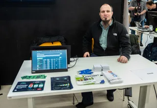 Photo of Gergely Daroczi sitting at the Spare Cores booth (table) at SFSCon 2024 in Bolzano, Italy.